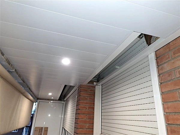 Tapa abierta junto a una persiana bajo un techo de aluminio DILUVID