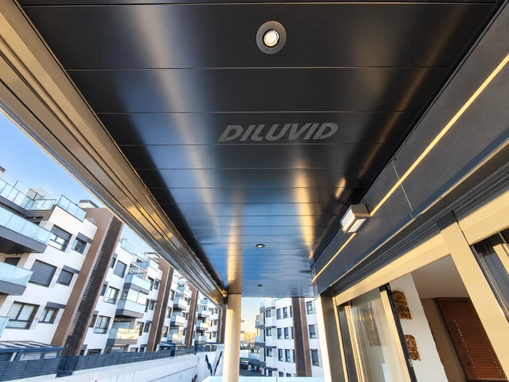 Techo de aluminio DILUVID negro mate con focos integrados en una terraza de Madrid